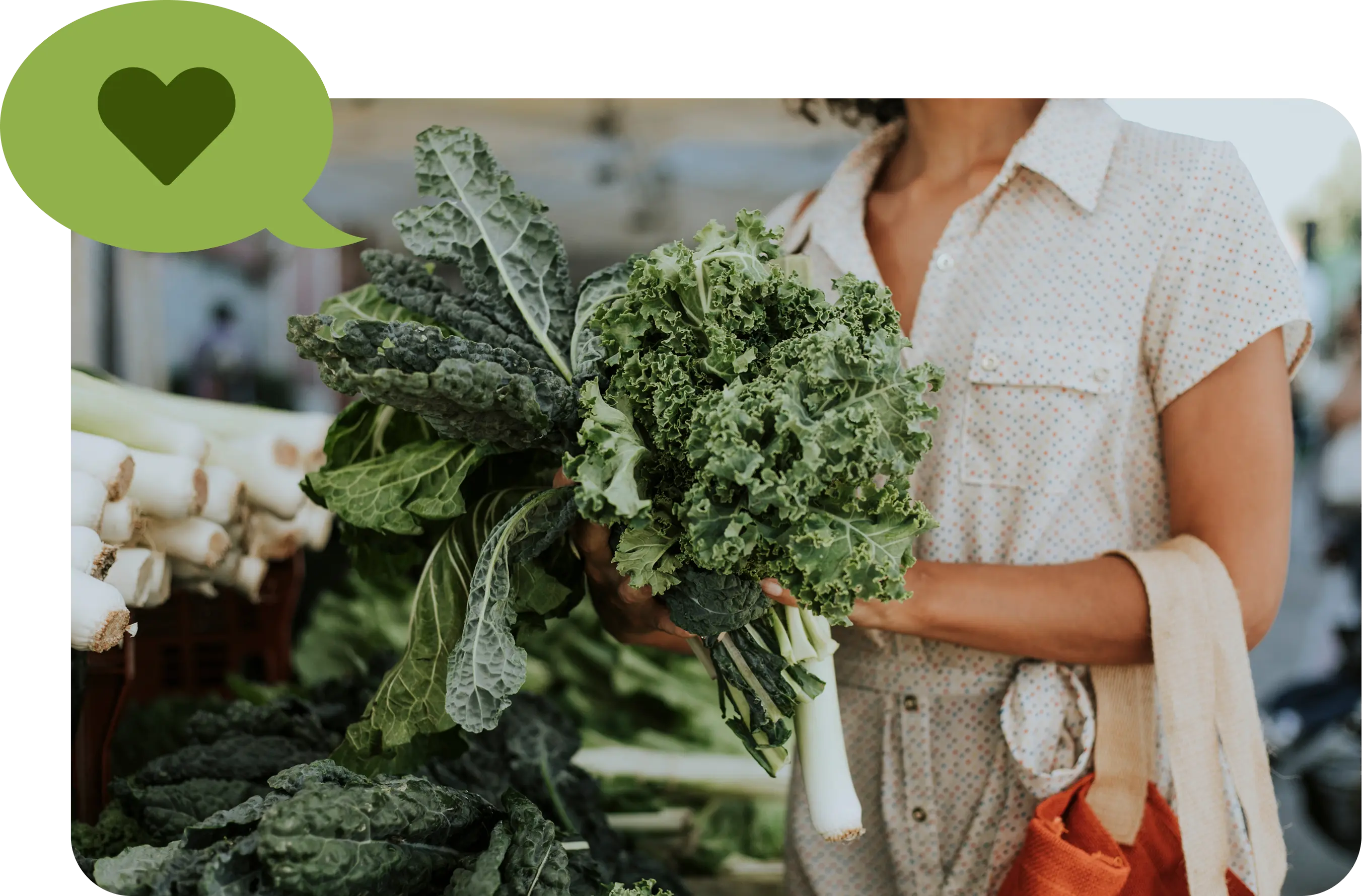 Woman holding a bunch of fresh kale and other leafy greens at a market, with a green speech bubble containing a heart